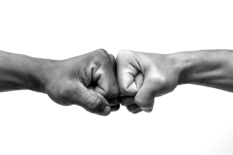 Two hands engaging in fistbump, trust